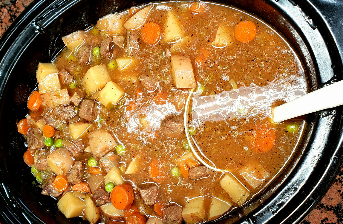 large crockpot full of cooked beef stew.