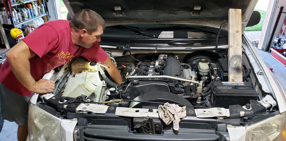 Mike under hood of truck for seasonal vehicle maintenance