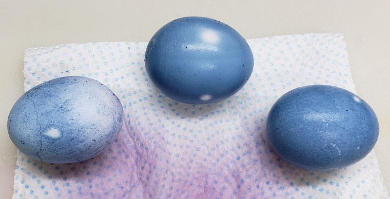 3 Easter eggs dyed blue sitting on a paper towel