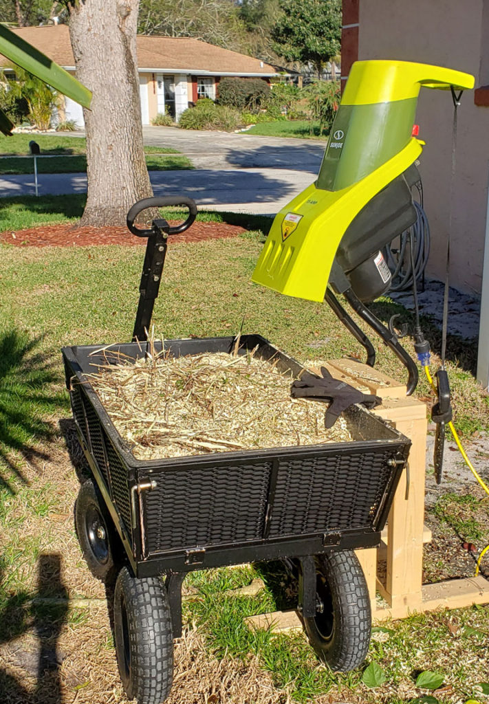 wood chipper and hand cart full of wood chips