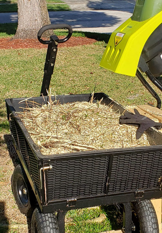 wood chipper and hand cart full of wood chips