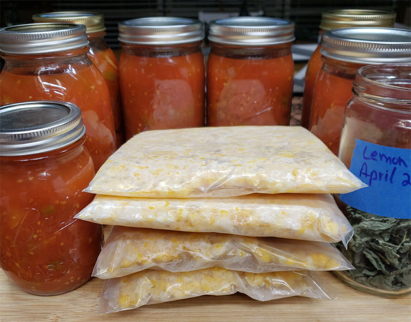 canned stewed tomatoes and frozen corn with a jar of dried lemon balm leaves.