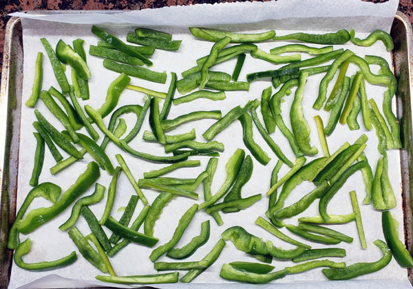 pepper slices on parchment paper on a cookie sheet