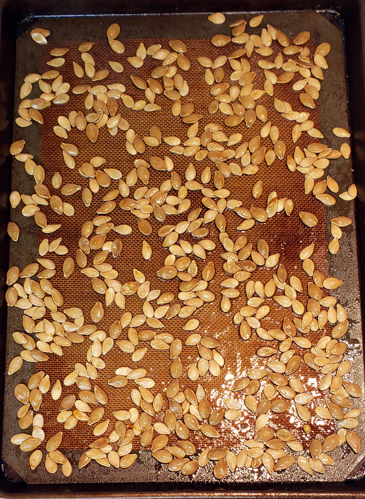 roasted pumpkin seeds on a silicone baking sheet.