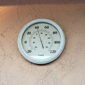 outdoor thermometer on a stucco wall reading forty degrees