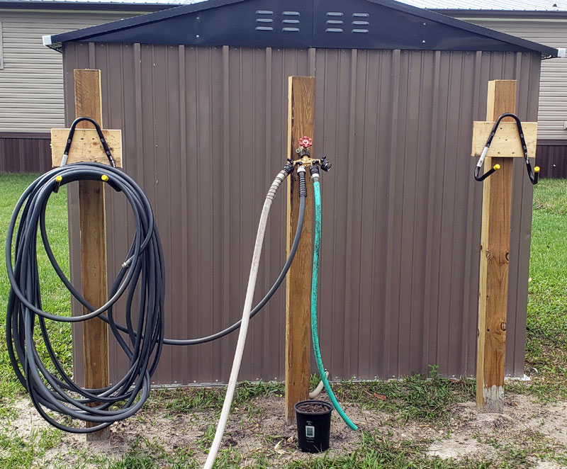 water spigot and hoses behind water well.