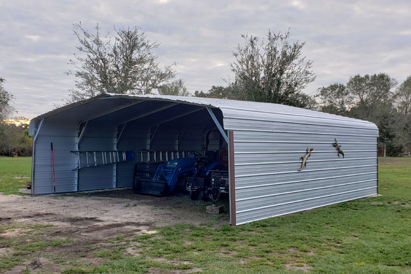 Completely assembled machine shed with tractor and implements inside.