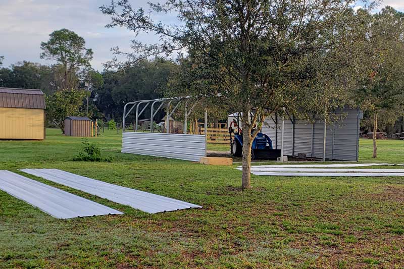 metal panels laid out on the grass ready to assemble onto the machine shed.