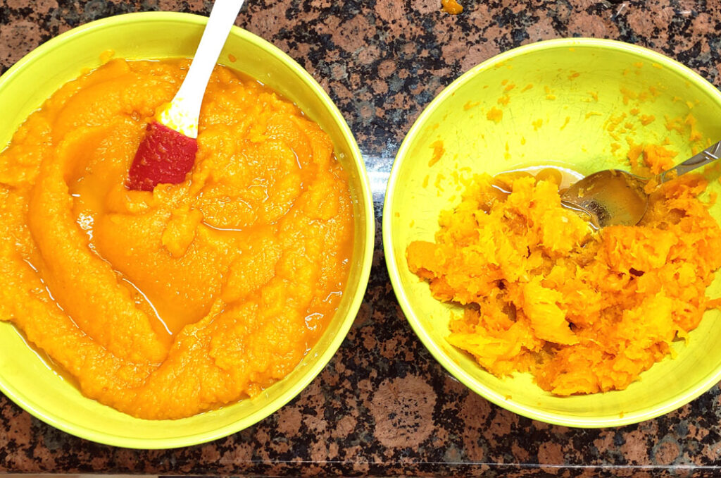 A bowl on the left with pureed pumkin in it and a silicone spatula. A bowl on the right with pumpkin flesh scraped out of the fruit.