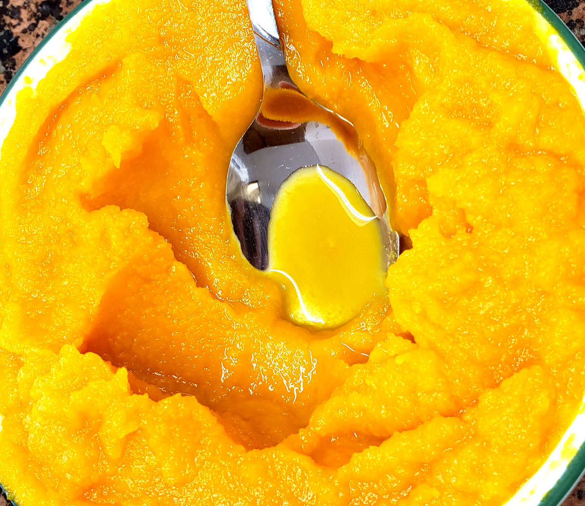 pumpkin puree in a bowl with a spoon.