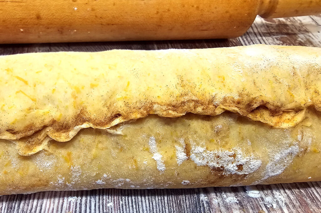 close-up of pumpkin dough rolled up. Edge is pinched tight.