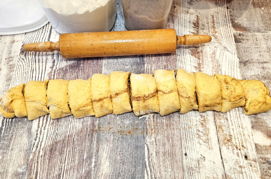 Pumpkin cinnamon roll dough cut into 12 pieces.