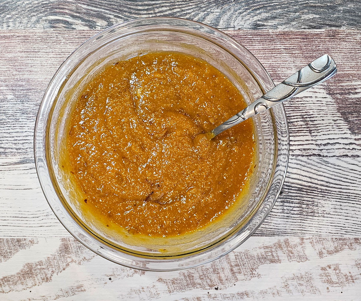 Wet ingredients for the bread in a glass bowl on a countertop.