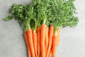 photo of carrots with tops on a white background.