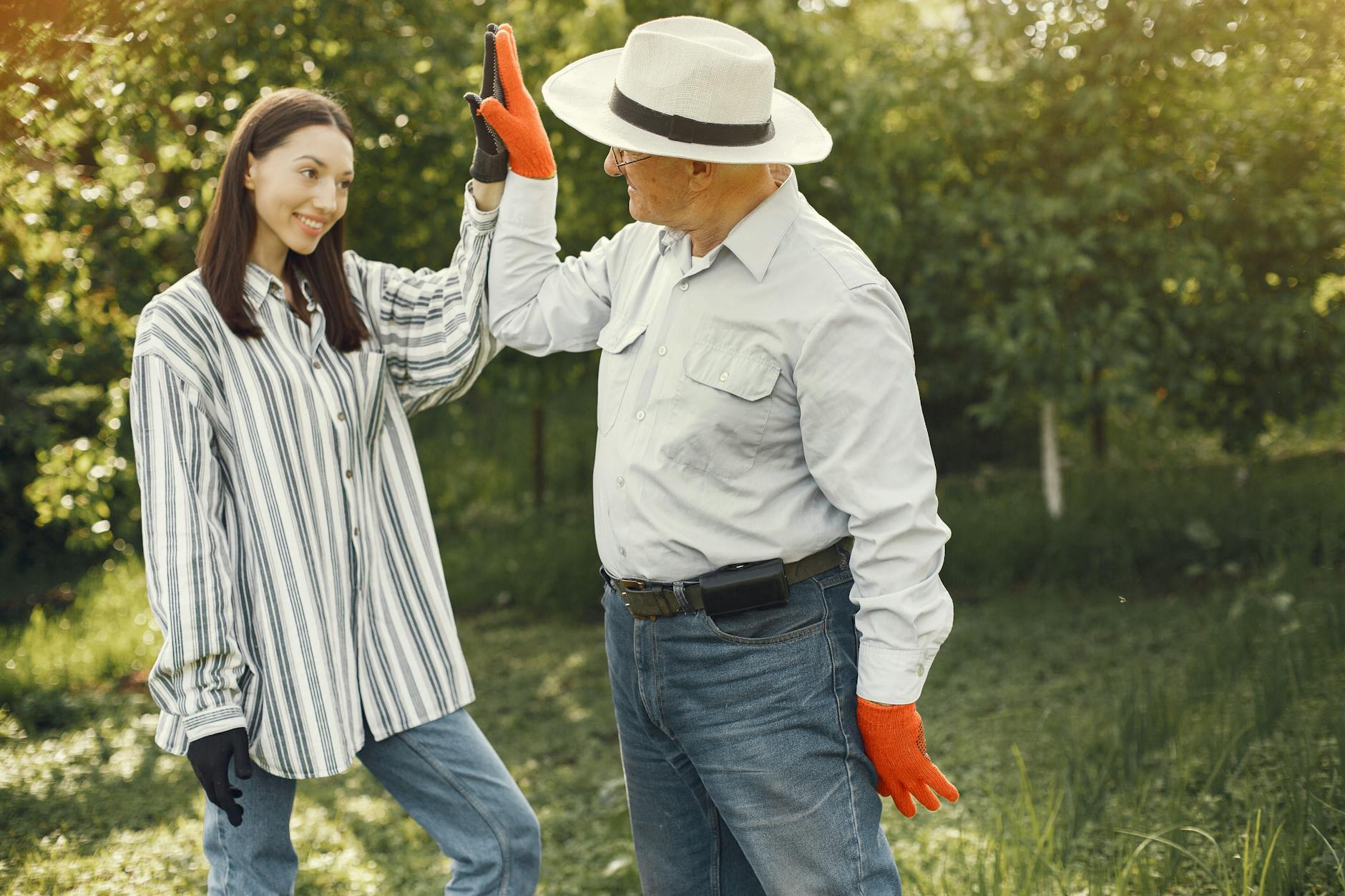 happy young woman and old man farmers giving high five