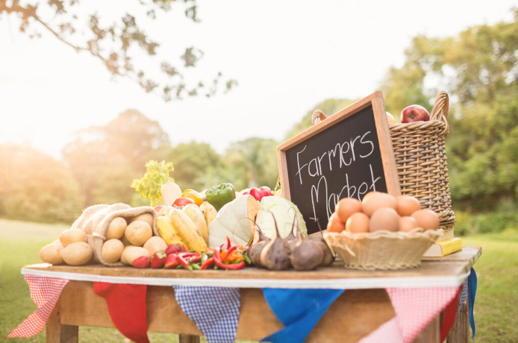 Table with fresh produce and eggs ready to sell at the farmers market.