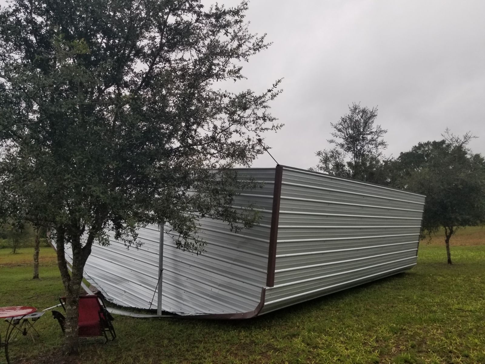 Photo of an upside down metal building that was blown over by hurricane Ian.