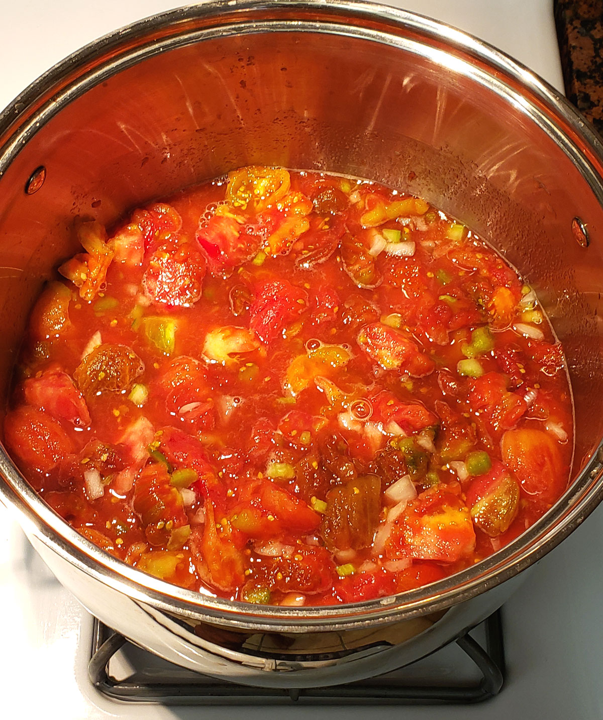 Stewed tomatoes cooking in a large stock pot.