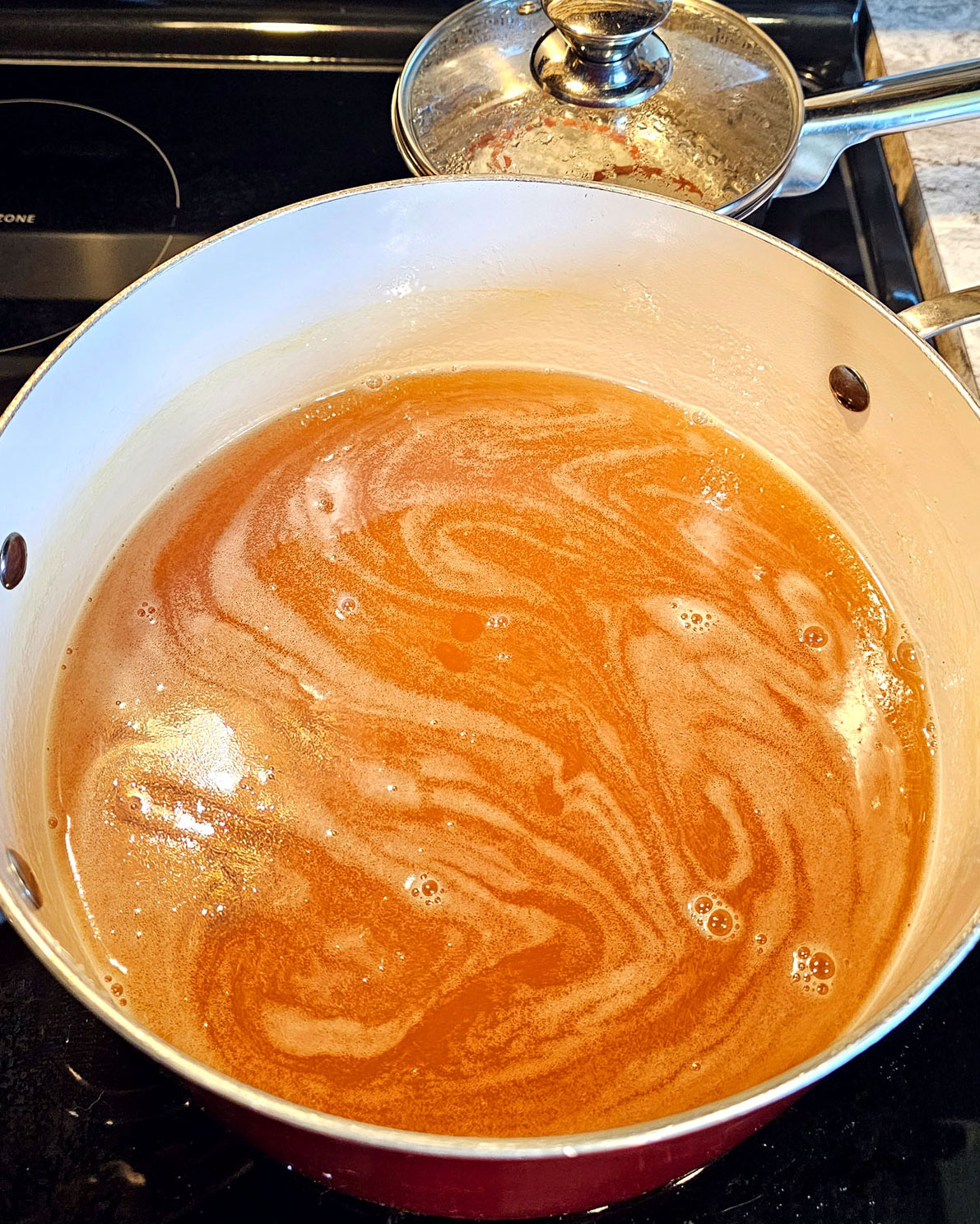 a stock pot half full of maypop juice and pectin being brought to a boil.