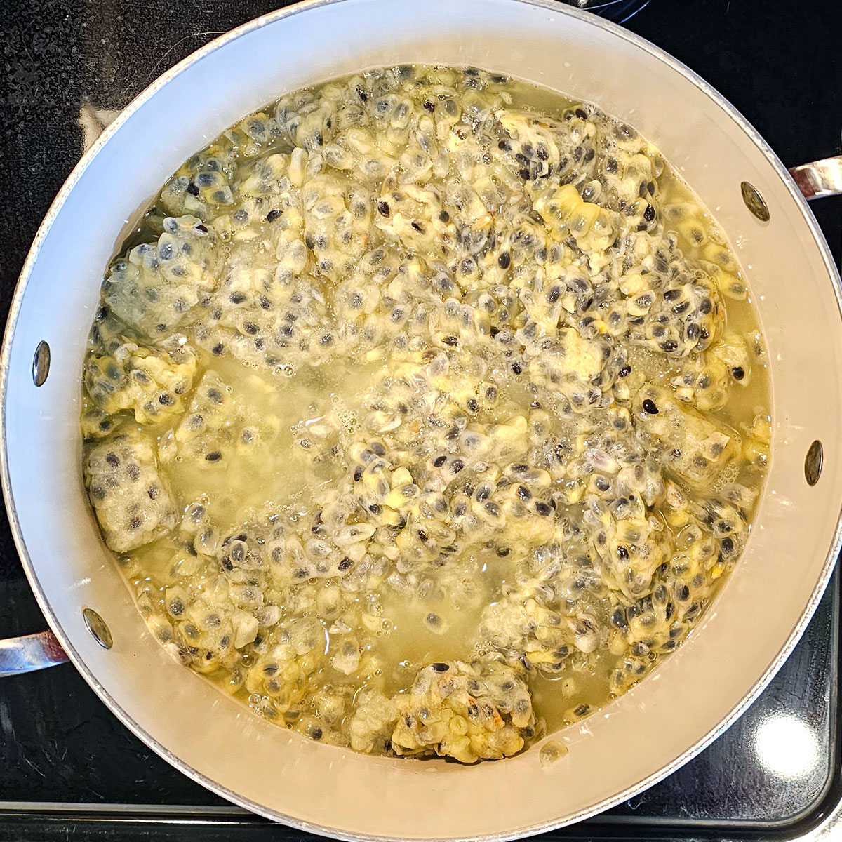 stoockpot half full of maypop pulp cubes thawing.