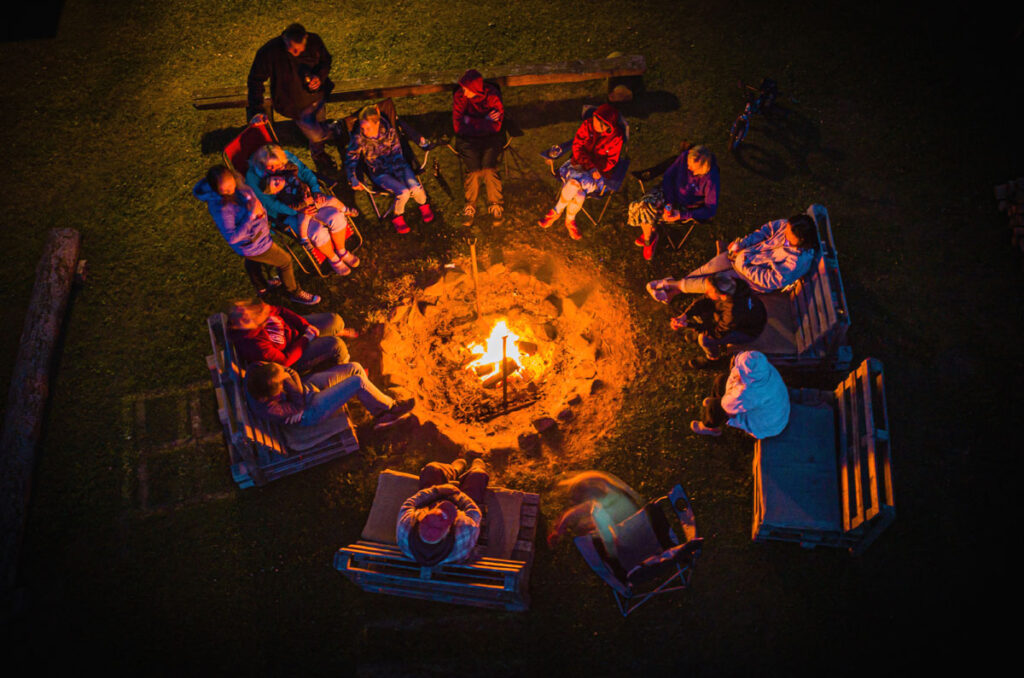 Overhead photo view of a gathering of people around a campfire at night.