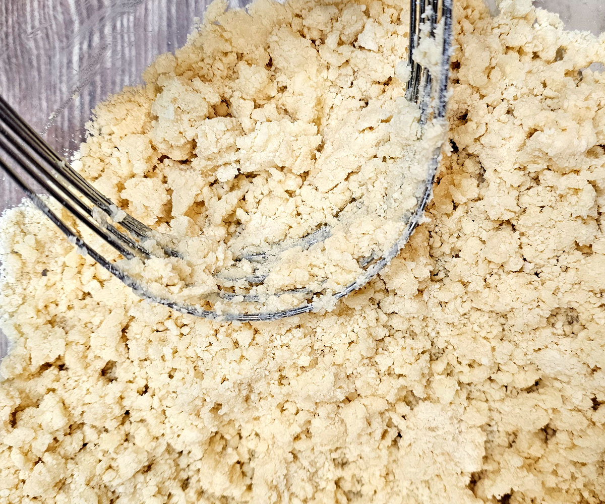 Close-up view of crust mixture of flour, powdered sugar and butter.