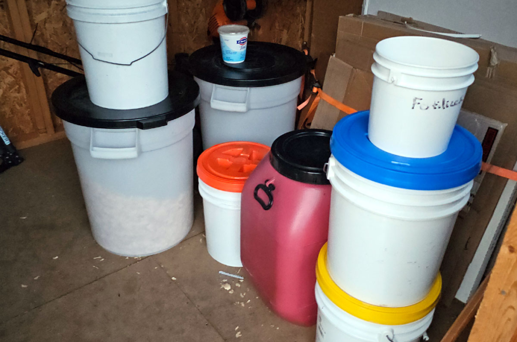 Photo of containers holding chicken feed, grit, calcium, and bedding.