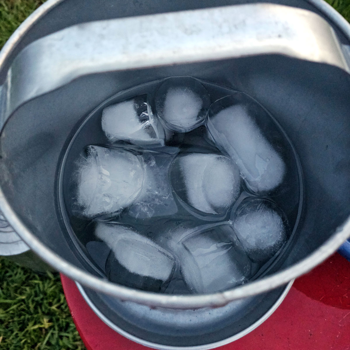 Close up photo of ice in a metal chicken waterer.
